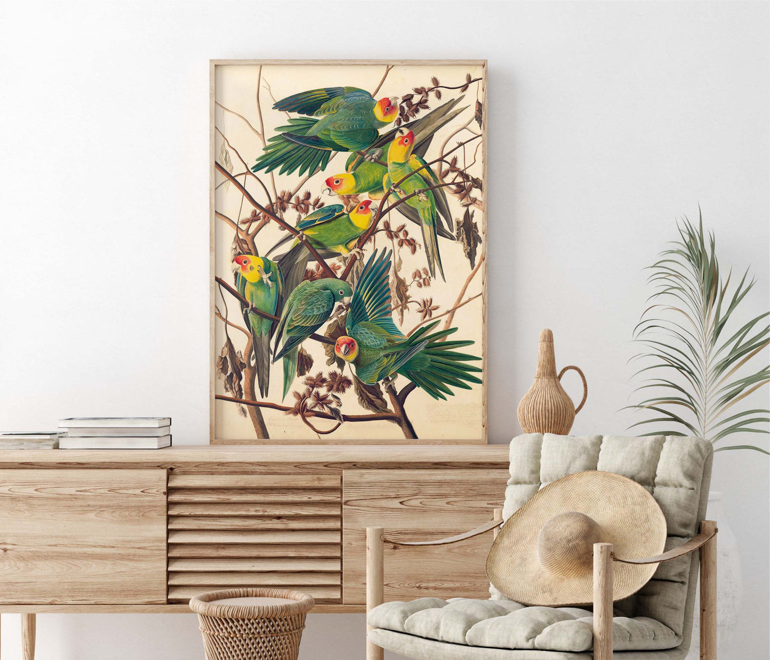 Framed artwork of parrots on a wall above a wooden console table with a chair and decorative items.
