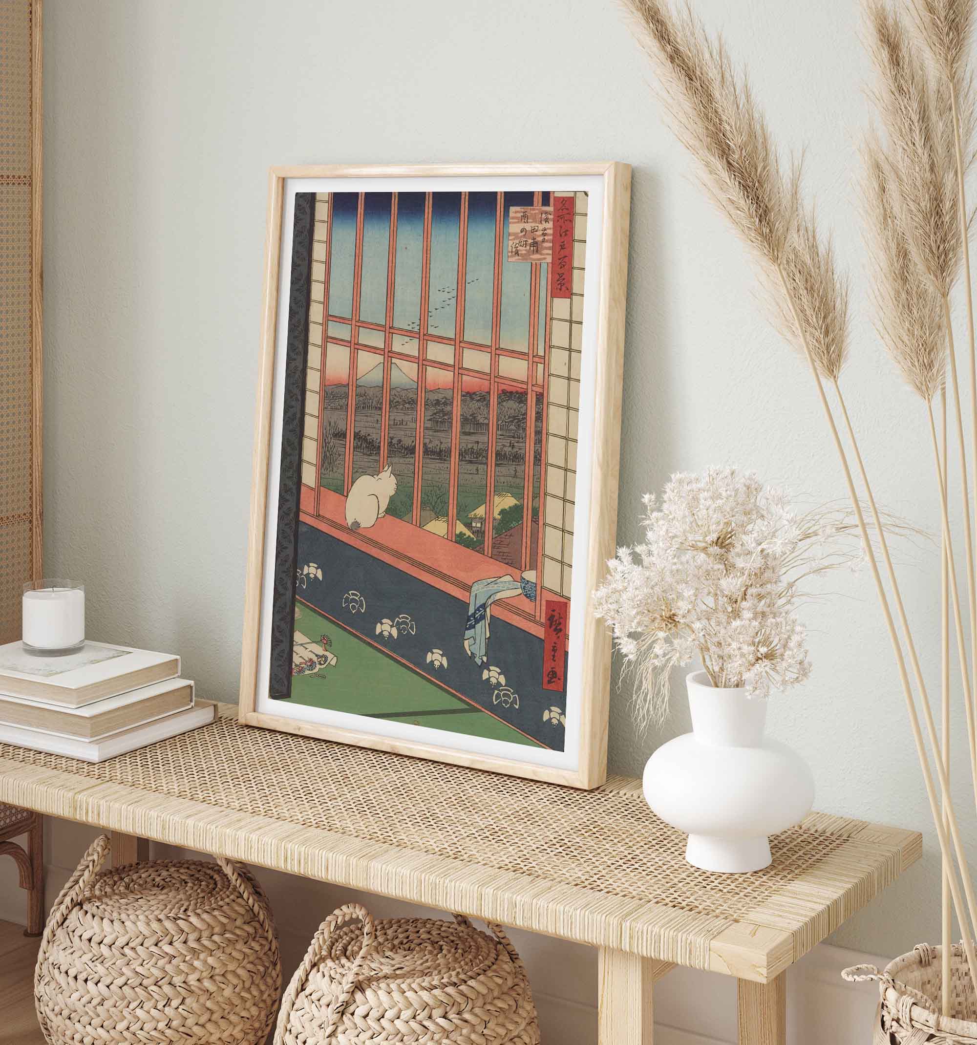 Framed japanese woodblock print by Hiroshige on a wooden console table with decorative elements.