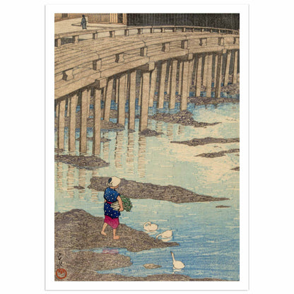 Japanese woodblock art print by Hasui Kawase — The Gion Bridge in Hondo, Amakusa. A wooden bridge with stone pillars spans a calm shallow river. Below, a woman in a blue dotted robe and red skirt carries vegetables along the rocky bank, while three white ducks float on the water. Shin-hanga style, circa 1922. Museum-quality reproduction print.