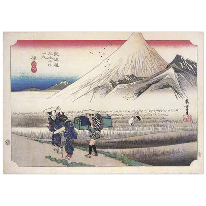 Japanese woodblock print by Hiroshige showing snow-capped Mount Fuji at dawn, two women travellers with a porter on a marsh path, and cranes taking flight.