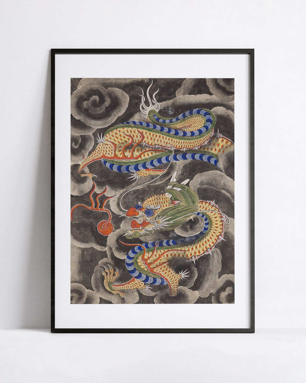 Korean minhwa painting of a dragon coiling through ink clouds toward a flaming pearl, art print shown in a black frame