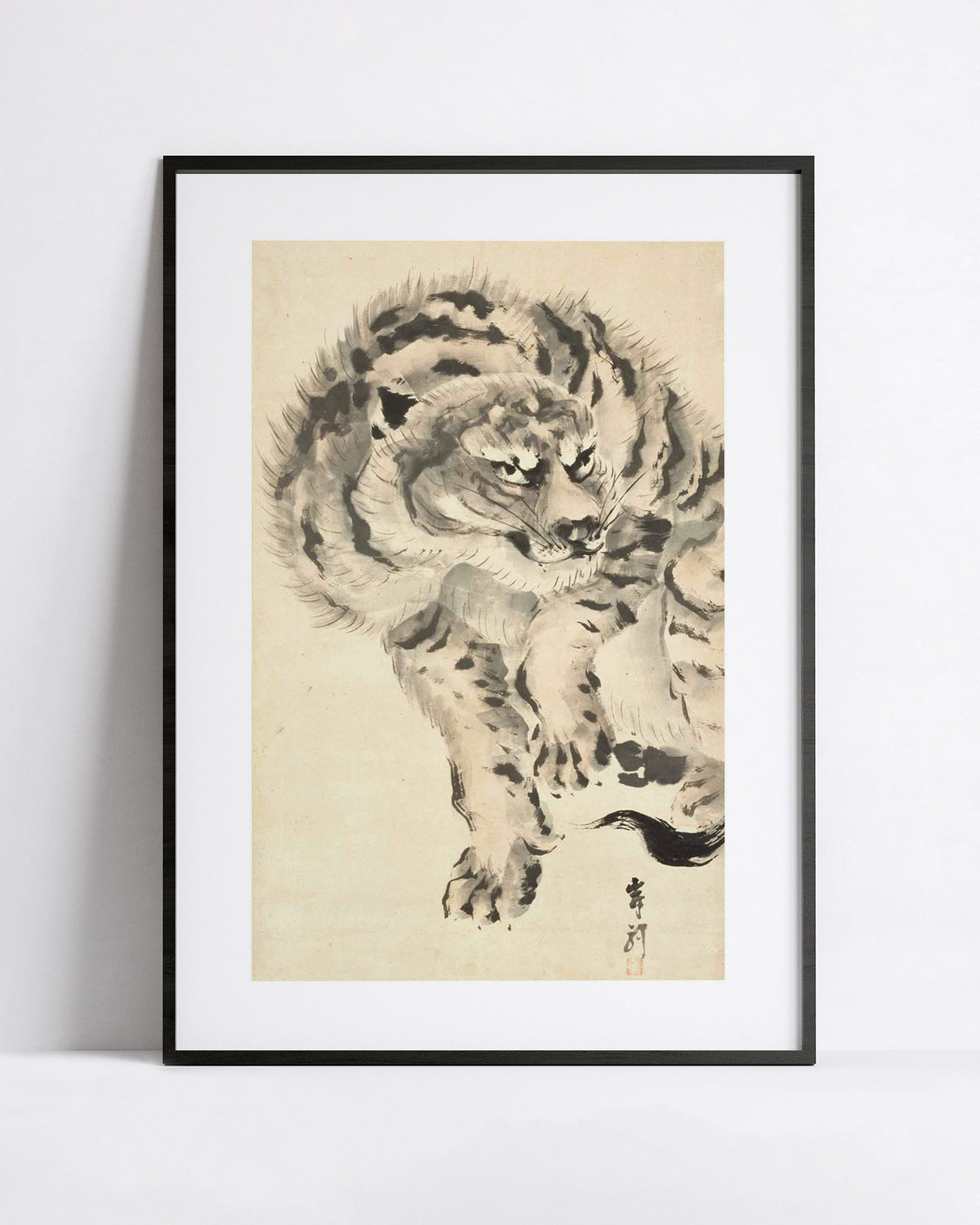 A framed art print featuring a detailed black and white ink painting of a japanese tiger on a beige background, displayed against a clean white wall.