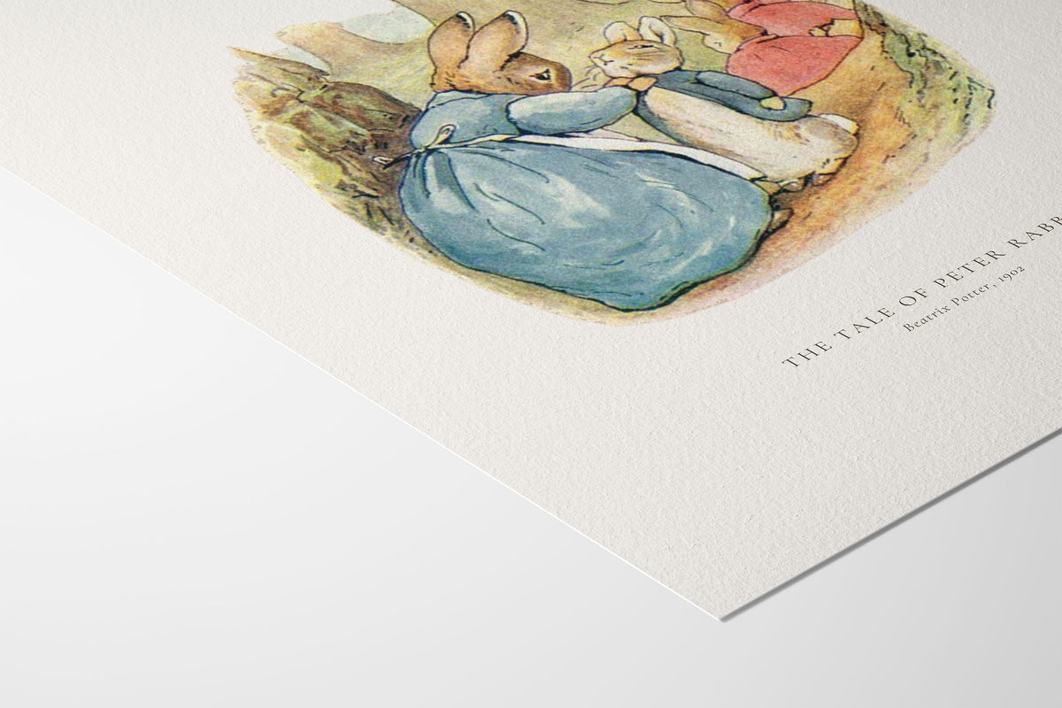 A close-up of a textured white art print featuring a watercolor illustration of Peter Rabbit and his mother from 'The Tale of Peter Rabbit'. The print is angled diagonally on a clean white surface, with the title and artist name 'Beatrix Potter' printed in black text on the bottom right.