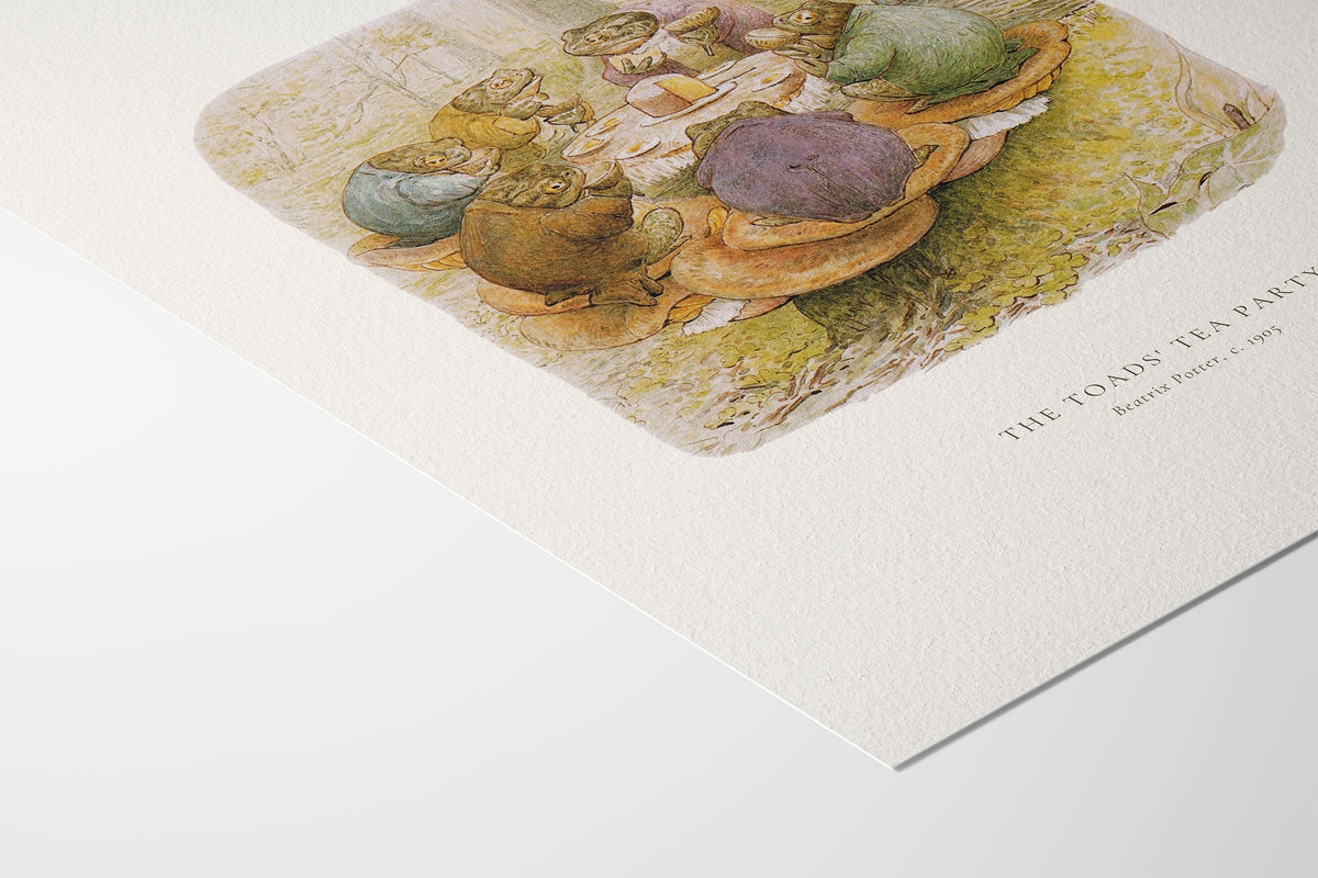 A close-up of a printed art poster showing a watercolor-style tea party scene with the title 'THE TOAD'S TEA PARTY' and 'Beatrix Potter, 1957' printed on the right side, photographed on a clean white background.